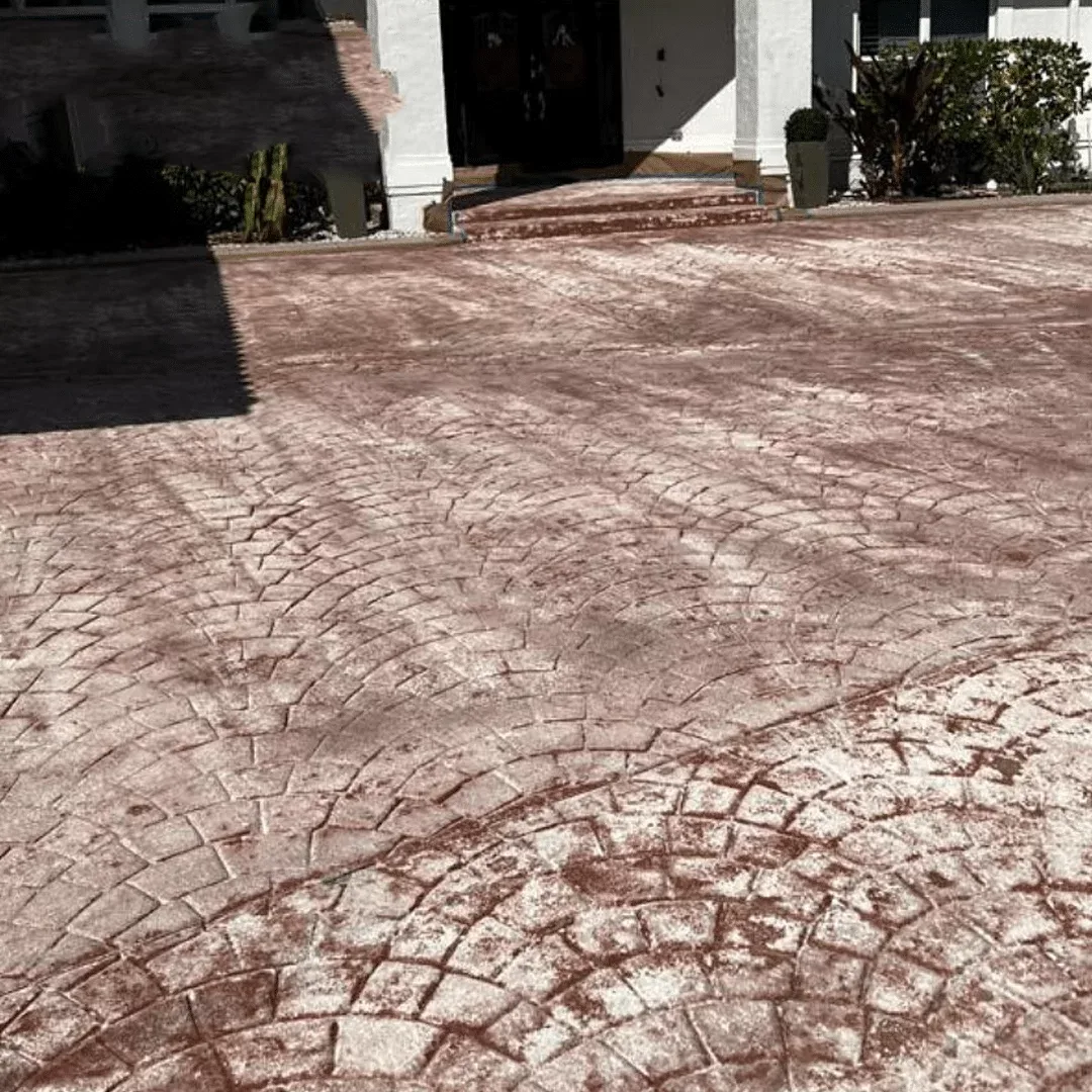 Stamped concrete driveway with a white, cloudy sealer